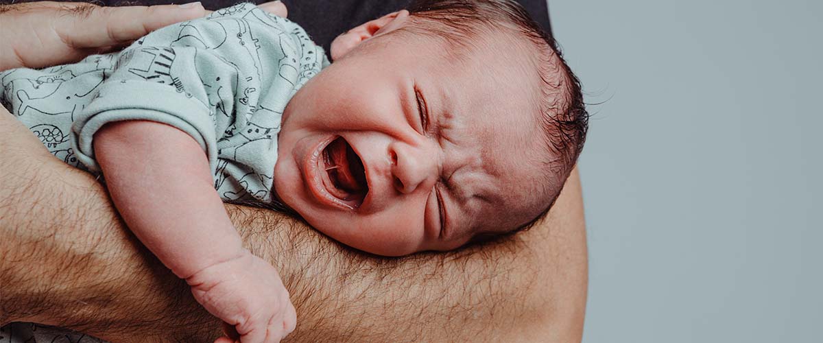 Spedbarn med kolikk som gråter