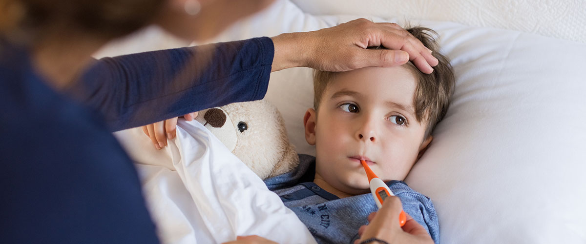 Gutt med feber som ligger i sengen