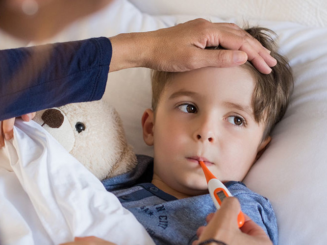 Gutt med feber som ligger i sengen