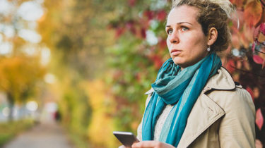 kvinne 40 titter bekymret ut i luften. høstbakgrunn. foto.