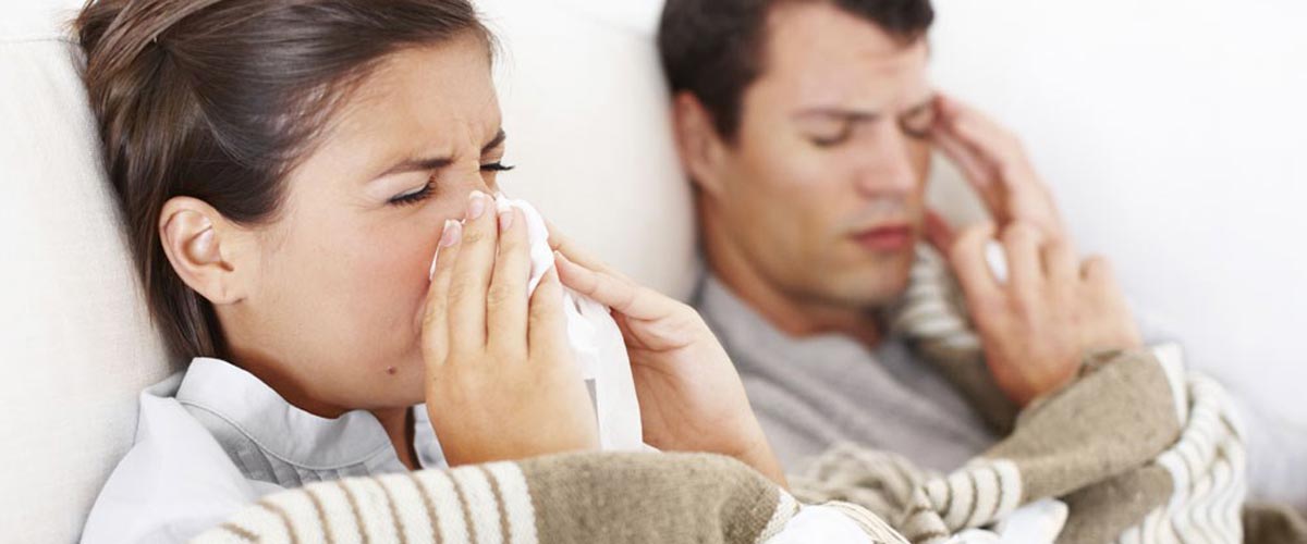 Forkjølet par som ligger i sengen