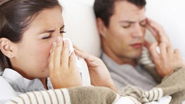 Forkjølet par som ligger i sengen