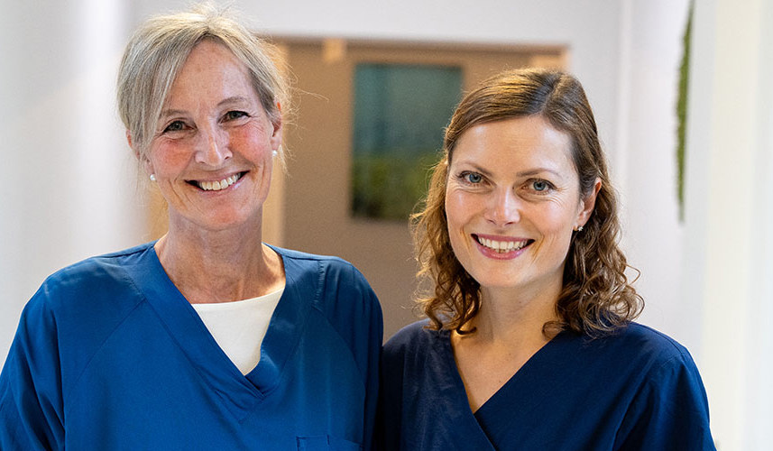 To kvinnelige leger som smiler til kamera.