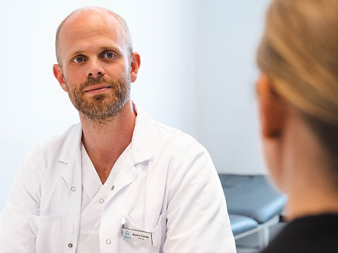 onkolog Flatebø i konsultasjon med kvinnelig pasient.