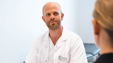 onkolog Flatebø i konsultasjon med kvinnelig pasient.
