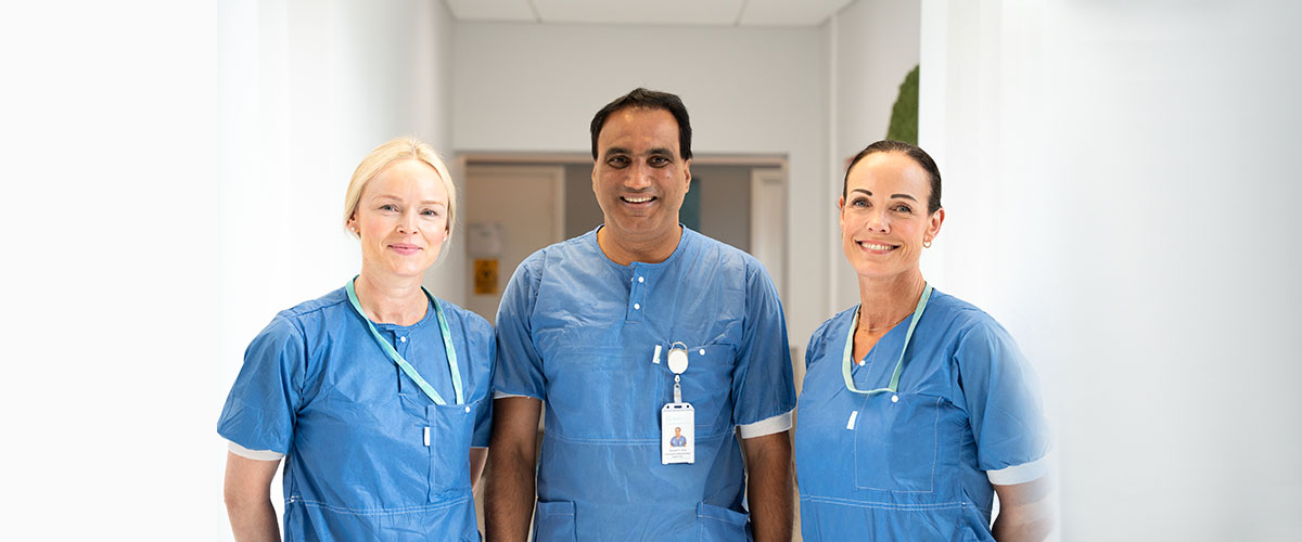 Tre smilende ansatte som arbeider ved gastrolabben.