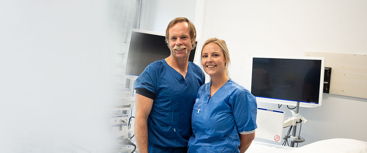 En mann og en kvinne smiler til kamera. Begge to arbeider på Aleris gastroavdeling.