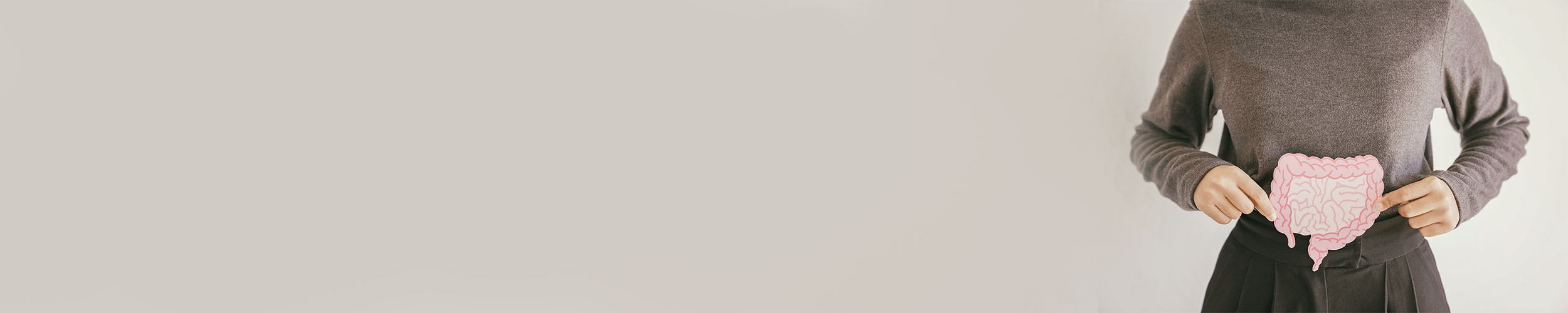 Hender som holder en lyserosa tegning av tarmen.