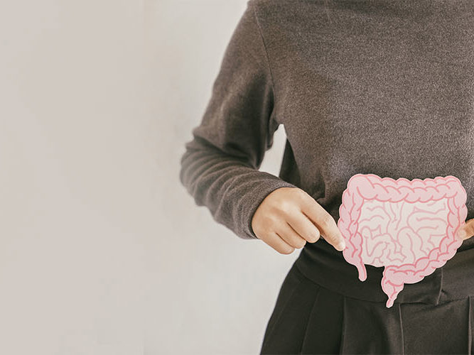 Hender som holder en lyserosa tegning av tarmen.