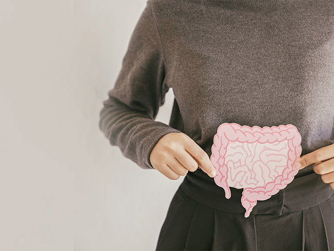 Hender som holder en lyserosa tegning av tarmen.