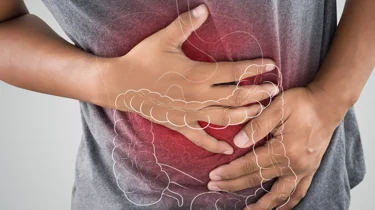 Hender som holder seg til magen. Et rødt område gløder rundt magen for å symbolisere smerte.