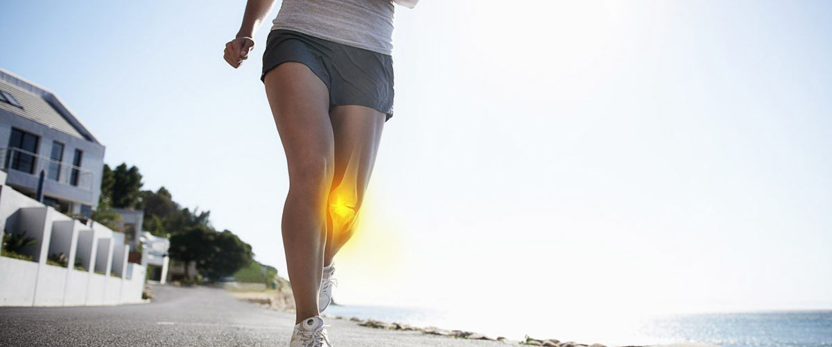 Kvinne løper med vondt i kne