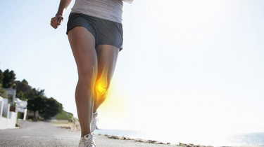 Kvinne løper med vondt i kne