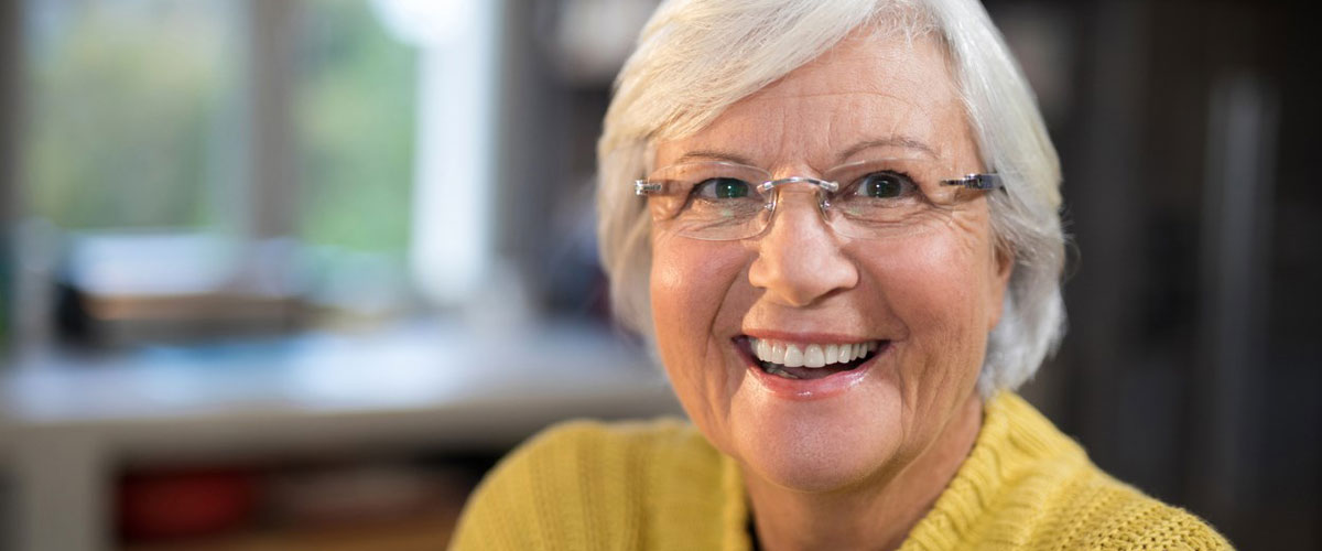 Eldre dame som som smiler til kameraet. foto. 