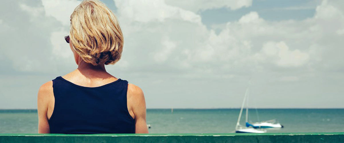 Kvinne sitter på en benk