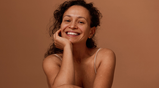 Smilende kvinne i studiobakgrunn