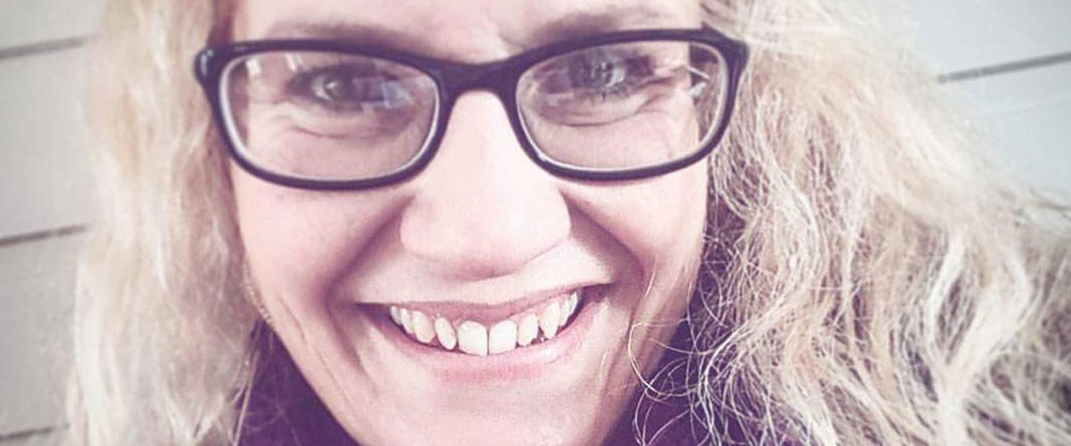 Smilende dame med briller.