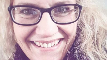 Smilende dame med briller.