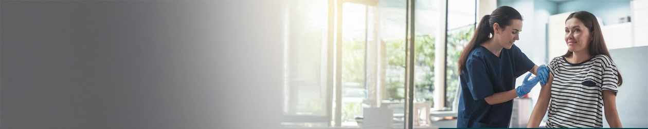 Kvinne får vaksine av lege