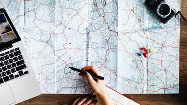 et stort kart liggende utbrettet på et bord. foto. 