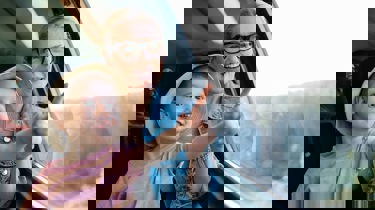 mor og datter sitter på toget og ser ut vinduet. 