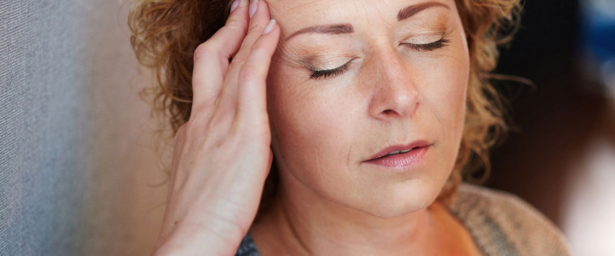 kvinne som tar seg til hodet. 