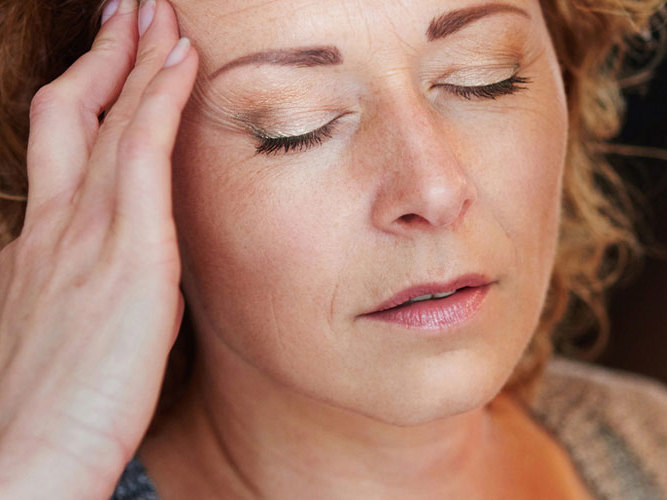 kvinne som tar seg til hodet.